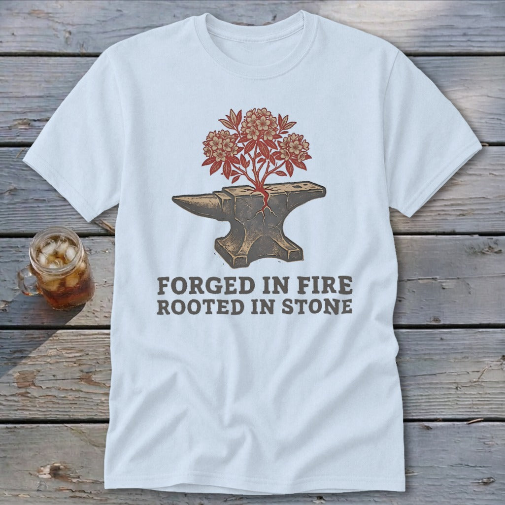 White t-shirt with an anvil, blooming tree, and text "FORGED IN FIRE ROOTED IN STONE."