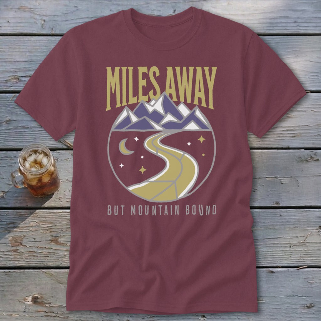 Maroon t-shirt with "Miles Away But Mountain Bound" graphic of mountains and road.