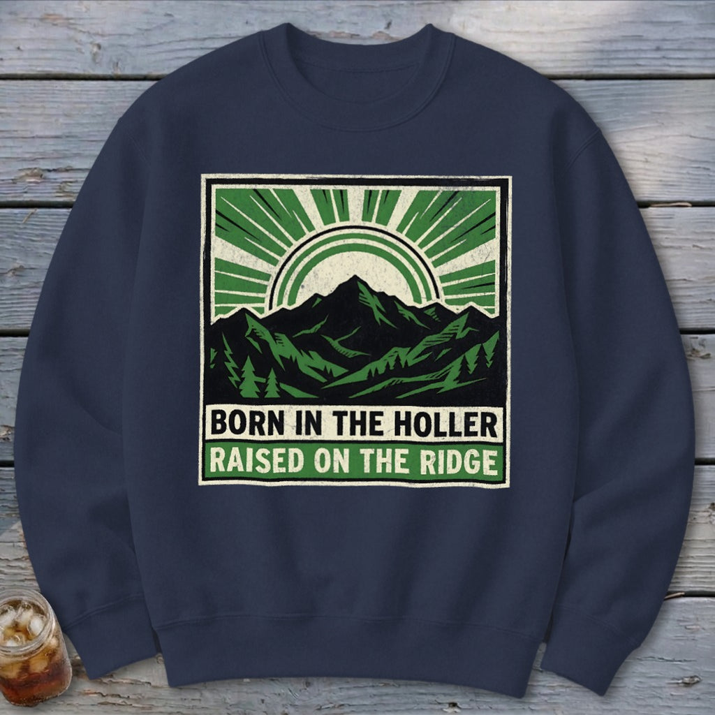 Dark blue crewneck sweatshirt featuring a graphic of mountains, trees, and text reading BORN IN THE HOLLER RAISED ON THE RIDGE.