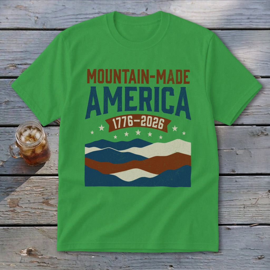 A bright green short-sleeve t-shirt with brown, blue, and white text and mountain graphics on the chest.