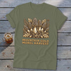 Olive green t-shirt with "MOUNTAIN GOLD MOREL HARVEST" text and mushroom graphic.