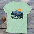 Light green t-shirt with "Ridge Runner Morning" text and mountain forest sunrise graphic.