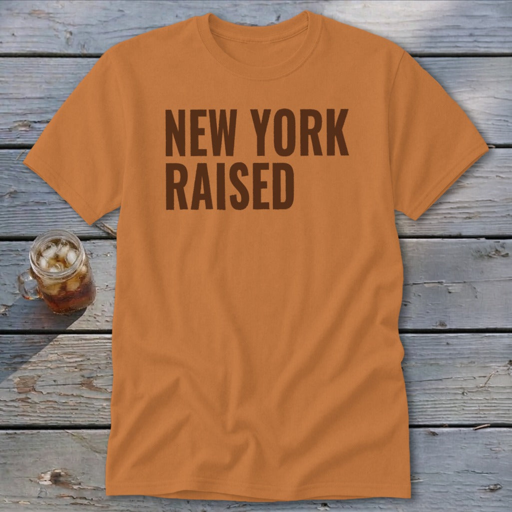 Orange t-shirt with "NEW YORK RAISED" printed in dark brown text.