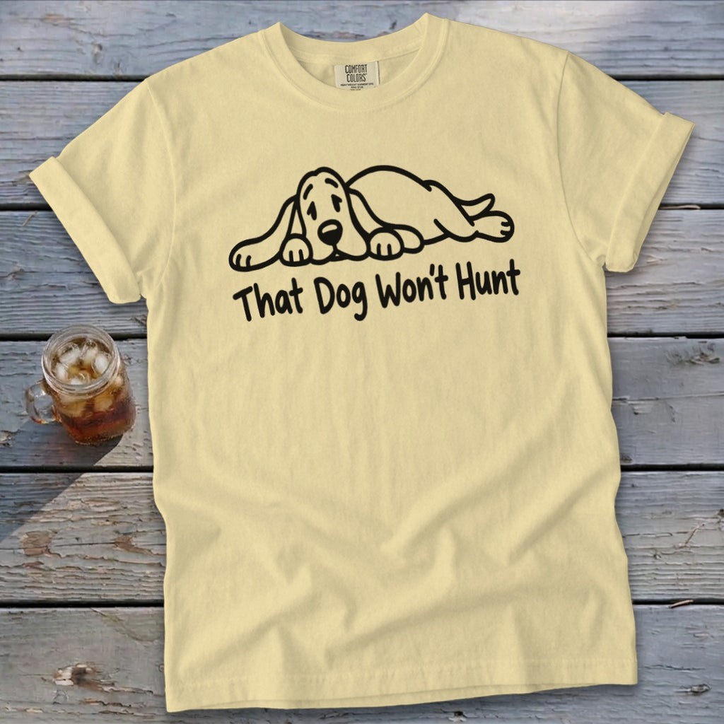 A pale yellow t-shirt featuring a black graphic of a sleeping hound dog and the text That Dog Wont Hunt.