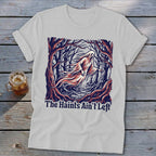 White t-shirt with a ghost in a forest and the text "The Haints Ain't Left".