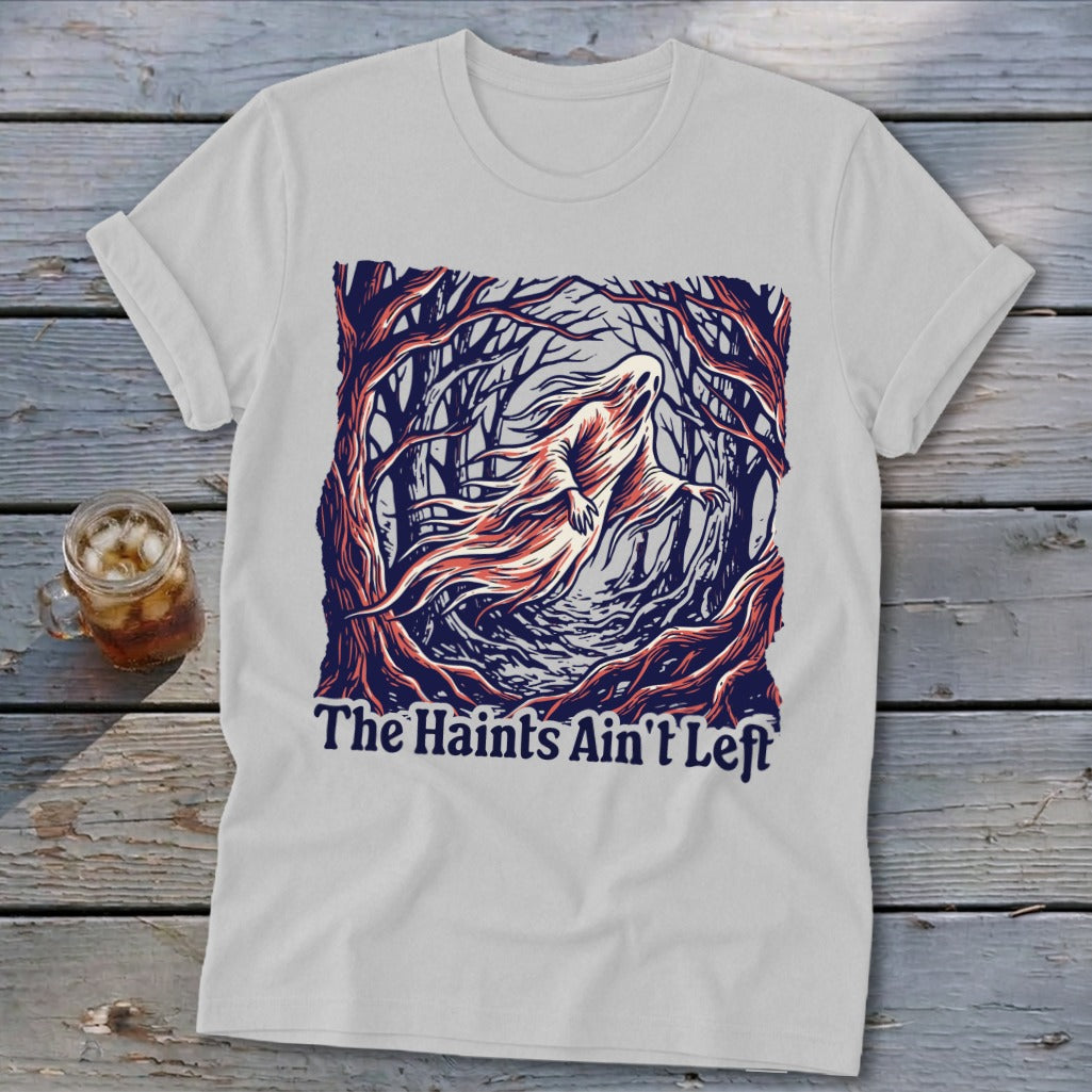 White t-shirt with a ghost in a forest and the text "The Haints Ain't Left".