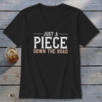 Black v-neck t-shirt with text "JUST A PIECE DOWN THE ROAD".