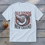 White t-shirt featuring a red and black graphic of a hand playing a banjo and text reading Old Sounds New Ground.