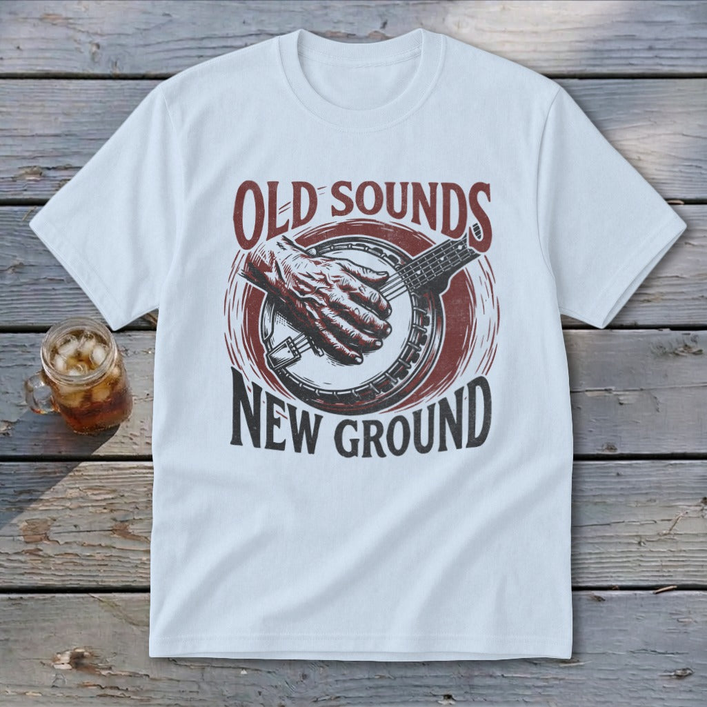 White t-shirt featuring a red and black graphic of a hand playing a banjo and text reading Old Sounds New Ground.