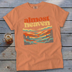 Orange t-shirt with "Almost Heaven" text and a retro landscape design.