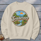 Cream sweatshirt with round graphic of Tennessee landscape with deer and sun.