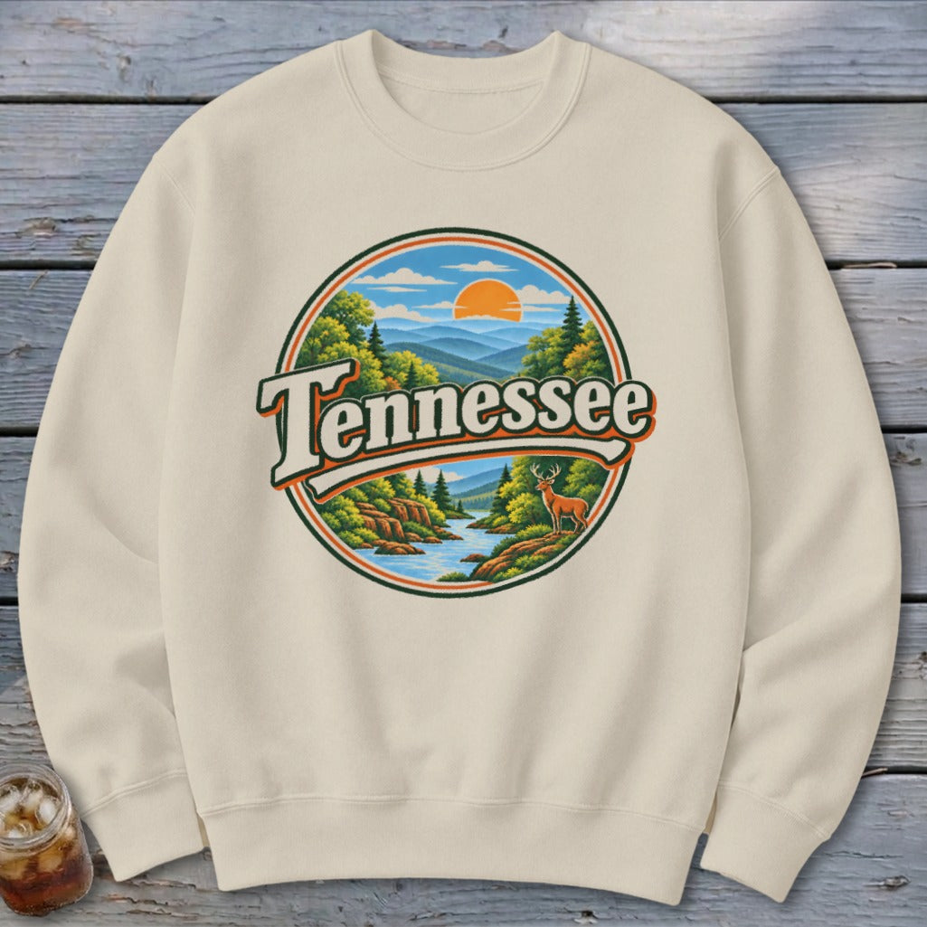 Cream sweatshirt with round graphic of Tennessee landscape with deer and sun.