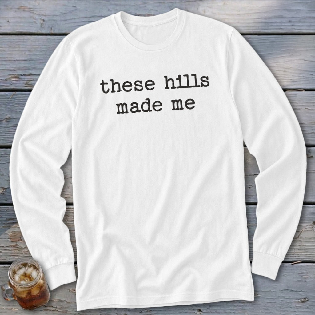 White long sleeve shirt with black text "these hills made me"