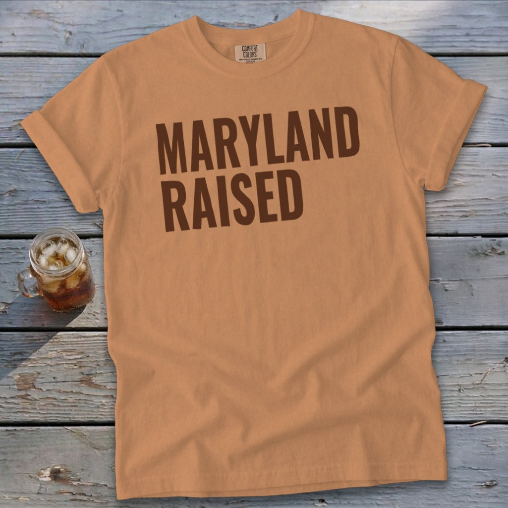 Peach Comfort Colors t-shirt with "MARYLAND RAISED" printed in brown.