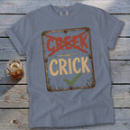 Blue t-shirt with a distressed sign graphic reading "CREEK" crossed out and "CRICK" with a checkmark.