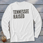 White long-sleeve shirt with "TENNESSEE RAISED" text in dark grey.