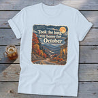 Light blue t-shirt with autumn mountain scene graphic that says "Took the long way home for October".