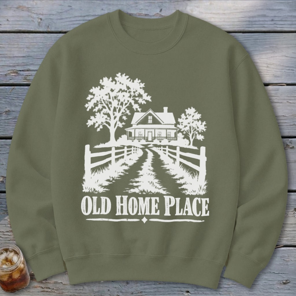 Olive green sweatshirt with white graphic of a house, trees, fence, and text "OLD HOME PLACE".