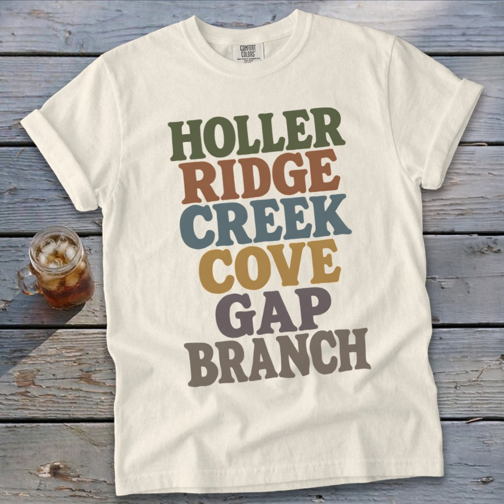Off-white t-shirt with stacked, multi-colored retro typography reading Holler Ridge Creek Cove Gap Branch.