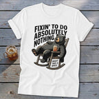 White t-shirt with a graphic of a black bear relaxing in a rocking chair, accompanied by text.