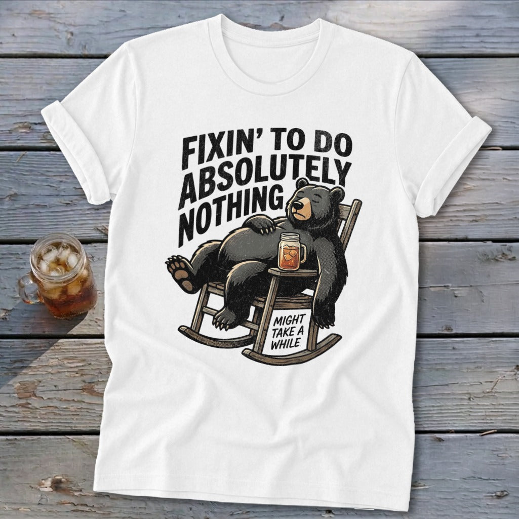 White t-shirt with a graphic of a black bear relaxing in a rocking chair, accompanied by text.