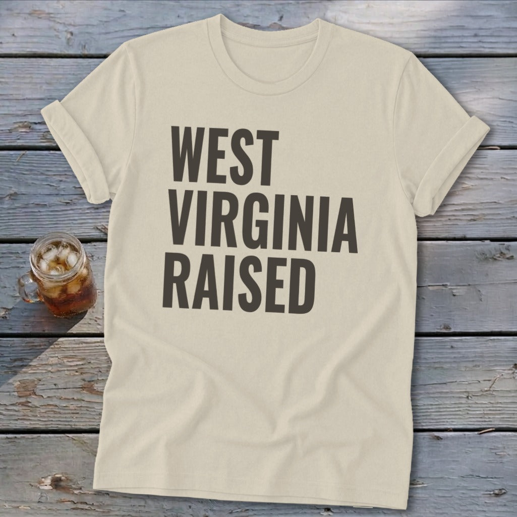 Light beige t-shirt with "WEST VIRGINIA RAISED" text in dark grey.