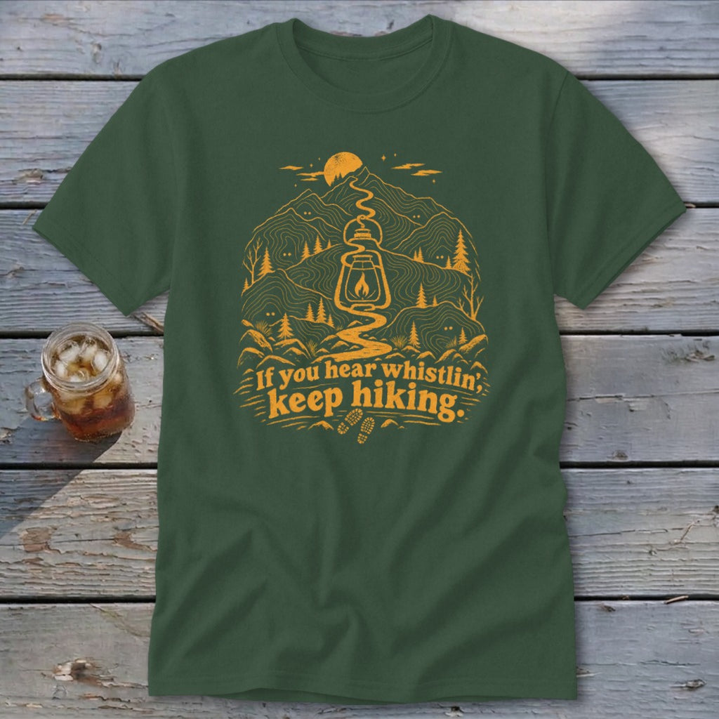 Green t-shirt with mountain graphic and "If you hear whistlin', keep hiking." text.