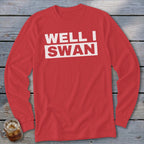 Red long-sleeve t-shirt with white text reading WELL I SWAN on a wooden background.