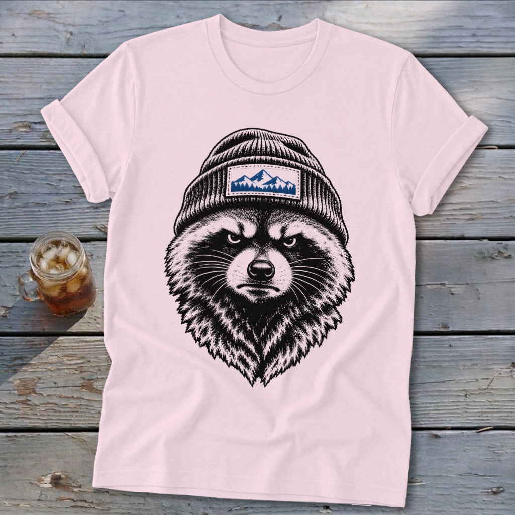 Pink t-shirt with a black and white sketch of a raccoon wearing a beanie with a mountain patch.