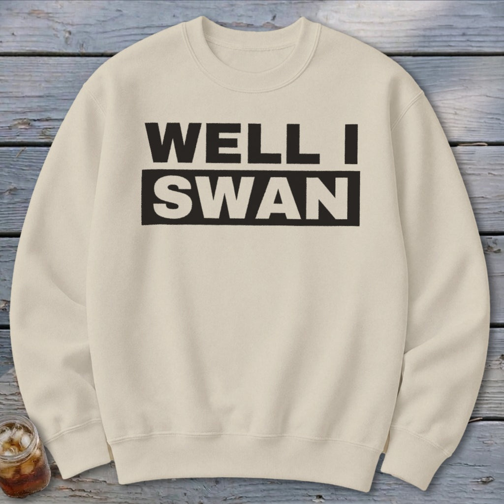 Beige crewneck sweatshirt featuring the black text WELL I SWAN laid out on two lines.