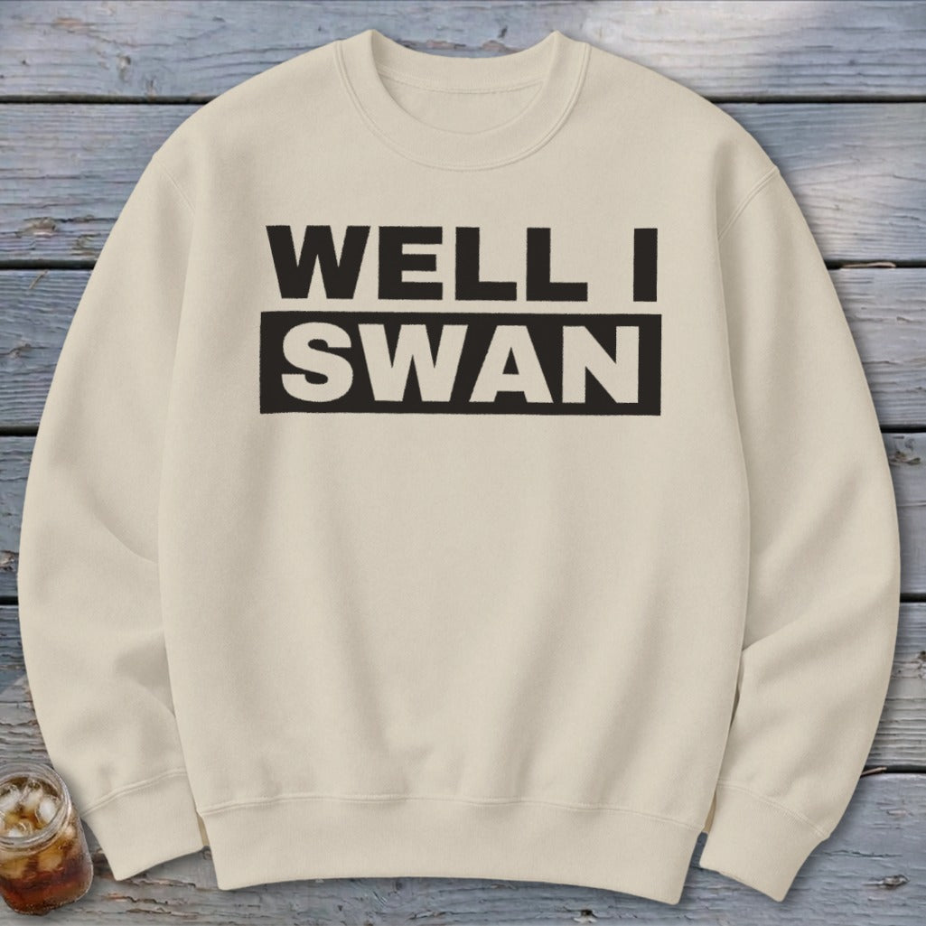 Beige crewneck sweatshirt featuring the black text WELL I SWAN laid out on two lines.