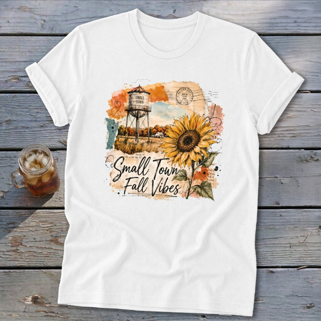 White t-shirt with "Small Town Fall Vibes" text, sunflower, and water tower graphic.