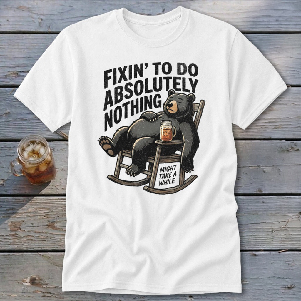White t-shirt featuring a cartoon bear relaxing in a rocking chair with text that reads Fixin to do absolutely nothing might take a while.