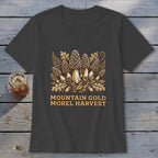 Dark grey v-neck t-shirt with "Mountain Gold Morel Harvest" text and mushroom graphic.