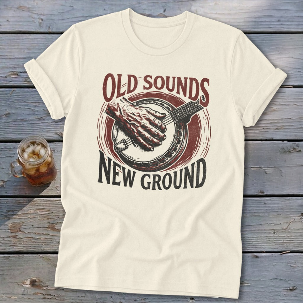 Cream crewneck t-shirt with a vintage-style graphic of a banjo player and text reading Old Sounds New Ground.