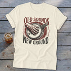 Cream crewneck t-shirt with a vintage-style graphic of a banjo player and text reading Old Sounds New Ground.