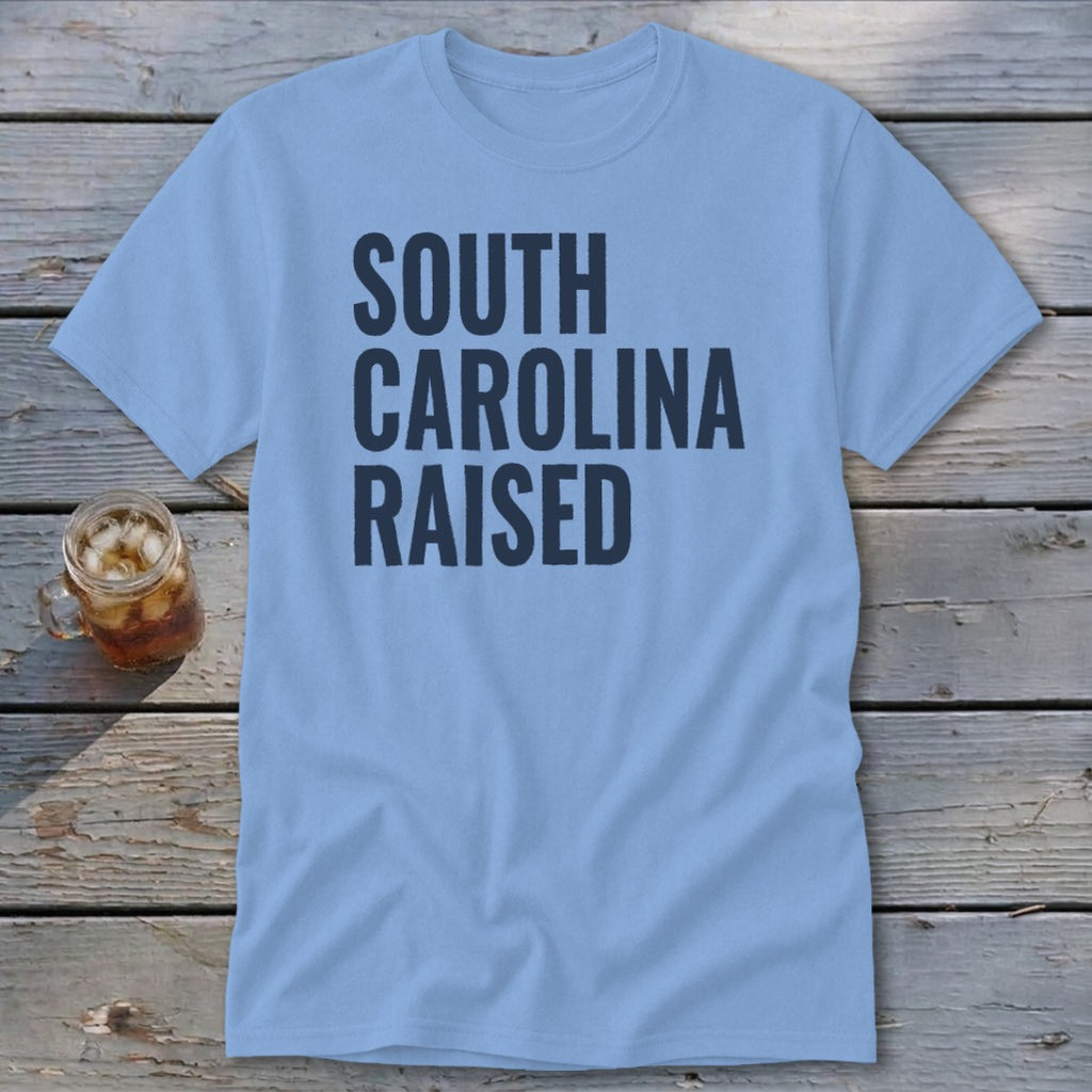 Light blue t-shirt with "SOUTH CAROLINA RAISED" text in dark blue.