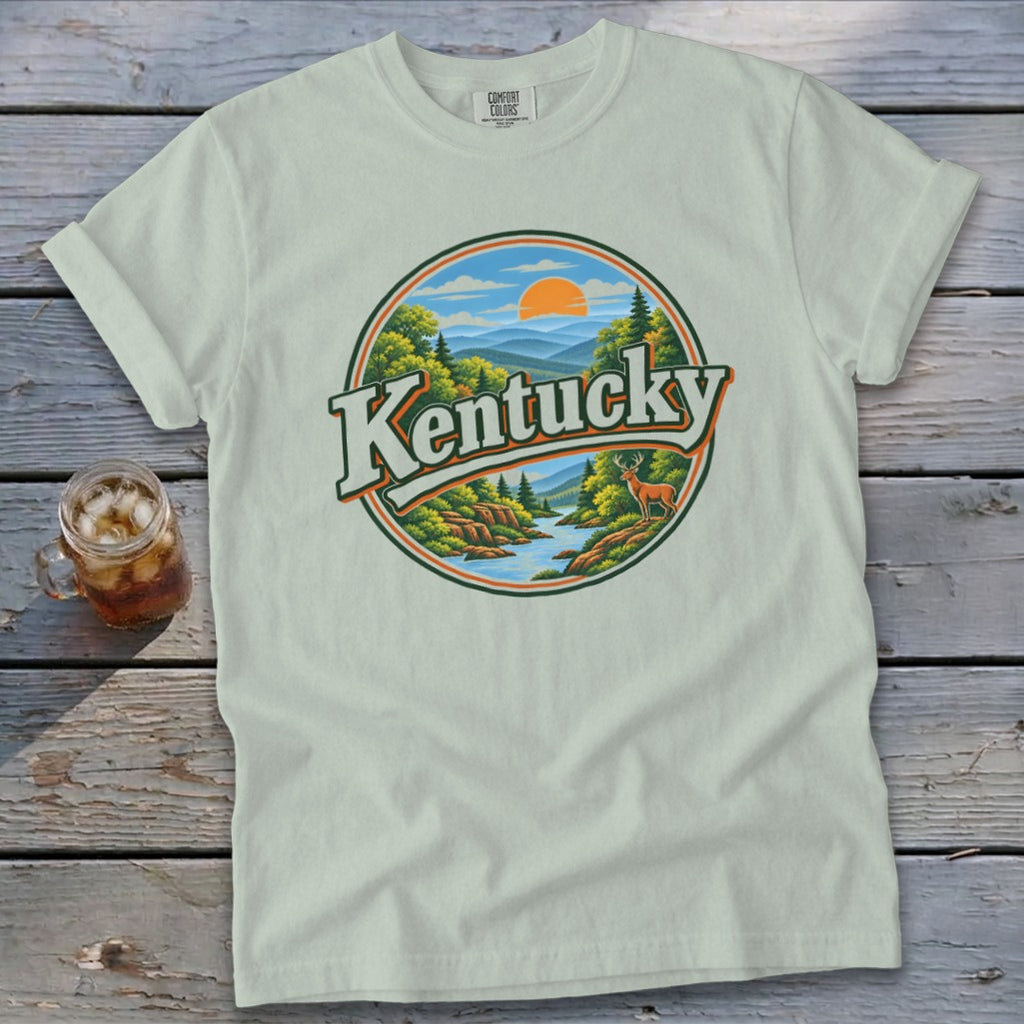 Light green t-shirt with circular "Kentucky" graphic featuring a scenic landscape and deer.