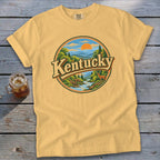 Yellow t-shirt with circular "Kentucky" landscape graphic featuring mountains, river, trees, and deer.