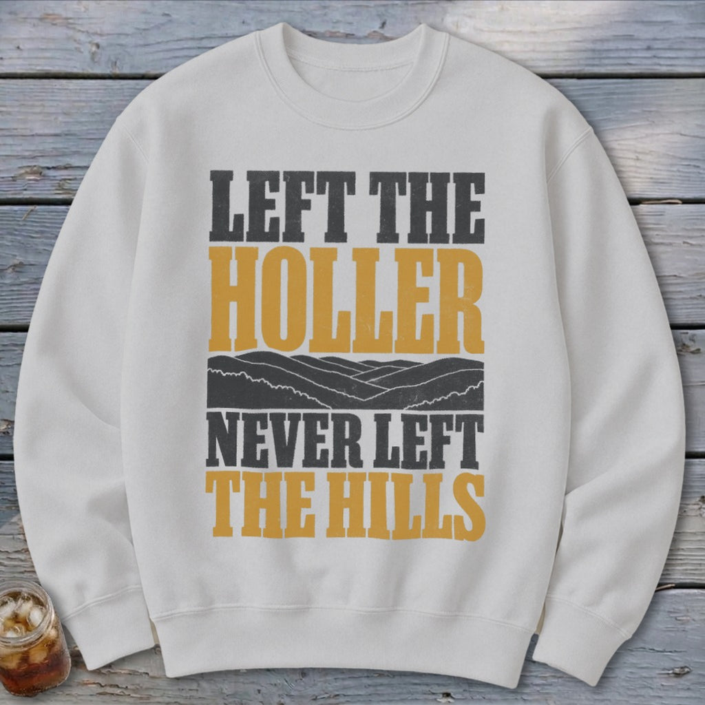 White sweatshirt with text "Left the Holler Never Left the Hills" and mountain graphic.