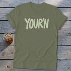 Olive green t-shirt with "YOUR'N" in light green text.