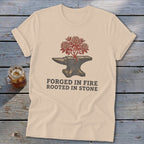 Cream t-shirt with an anvil, blooming tree, and text "FORGED IN FIRE ROOTED IN STONE".