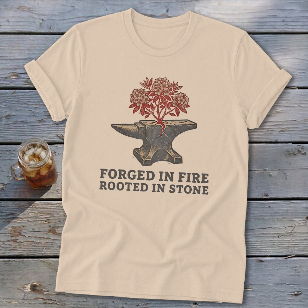 Cream t-shirt with an anvil, blooming tree, and text "FORGED IN FIRE ROOTED IN STONE".