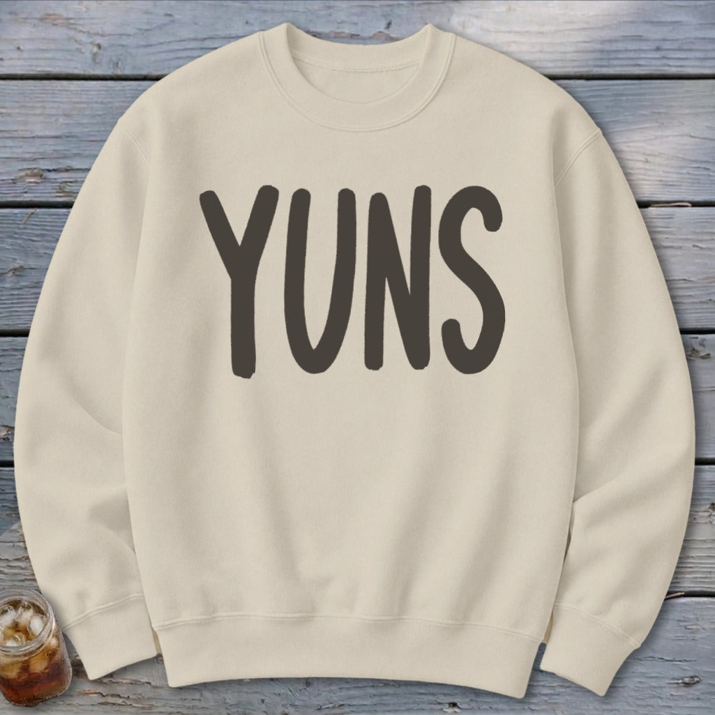 Cream sweatshirt with large dark gray "YUNS" text across the chest.