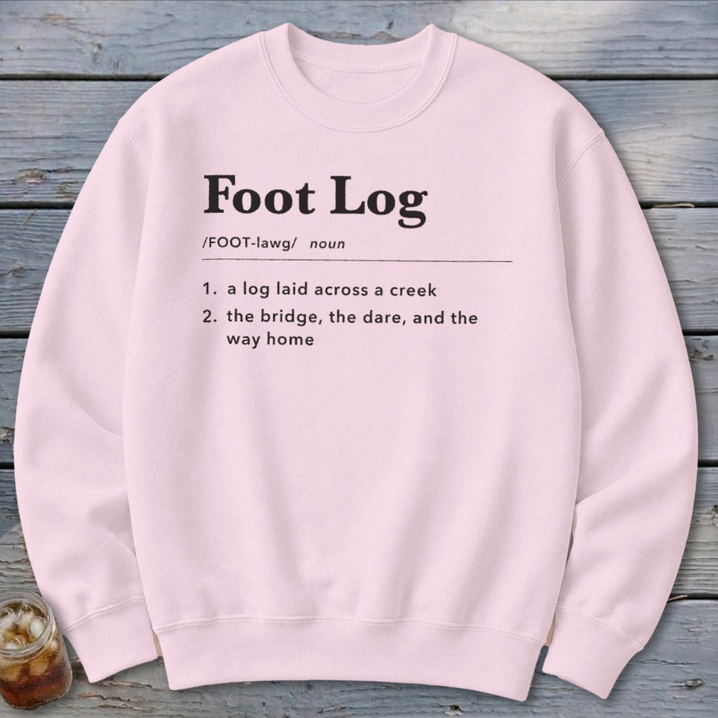 A light pink crewneck sweatshirt featuring black dictionary-style text that defines the term Foot Log.