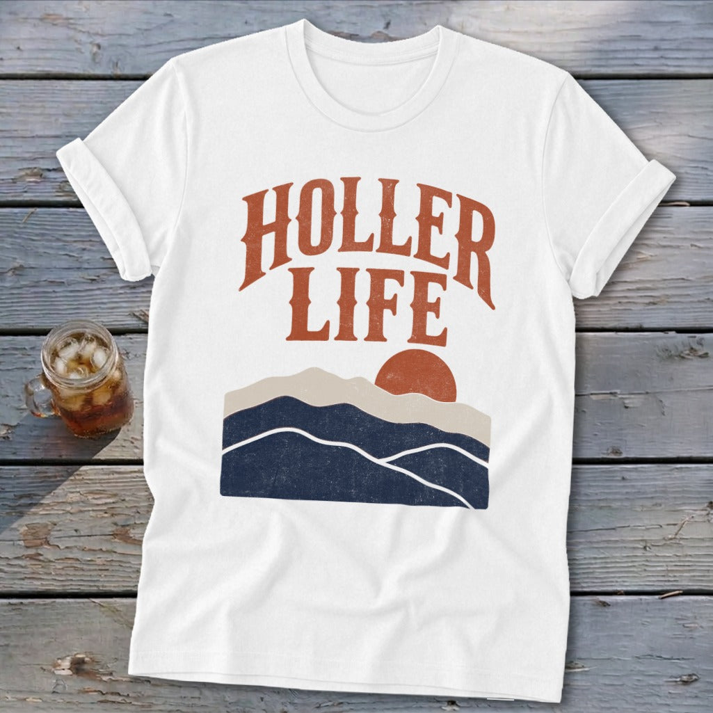 A white t-shirt featuring the text "HOLLER LIFE" above a retro mountain and sun graphic.