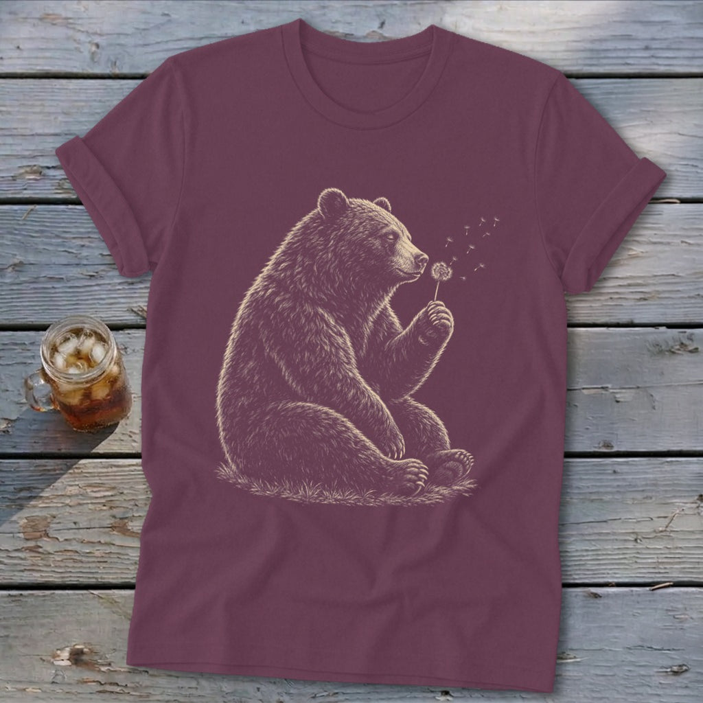 Maroon t-shirt with a drawing of a bear blowing on a dandelion.