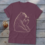 Maroon t-shirt with a drawing of a bear blowing on a dandelion.