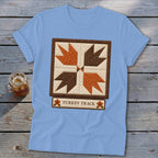 Light blue t-shirt with a square quilt block design featuring turkey tracks and the text "TURKEY TRACK".