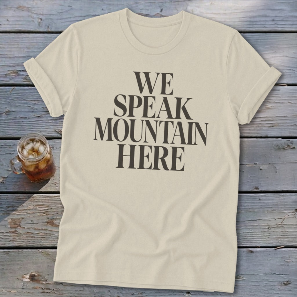 Cream t-shirt with dark text reading "WE SPEAK MOUNTAIN HERE"